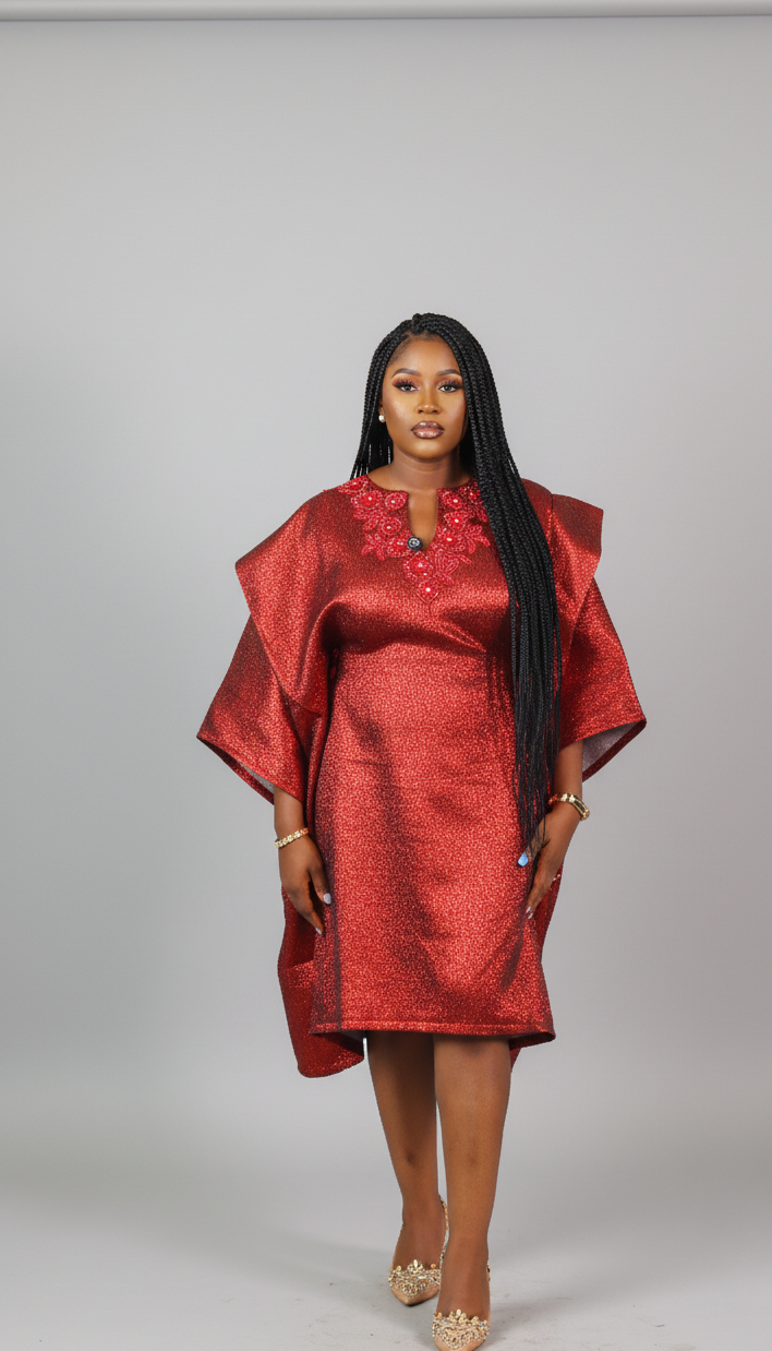 Woman wearing a red dress with floral embroidery on a gray background